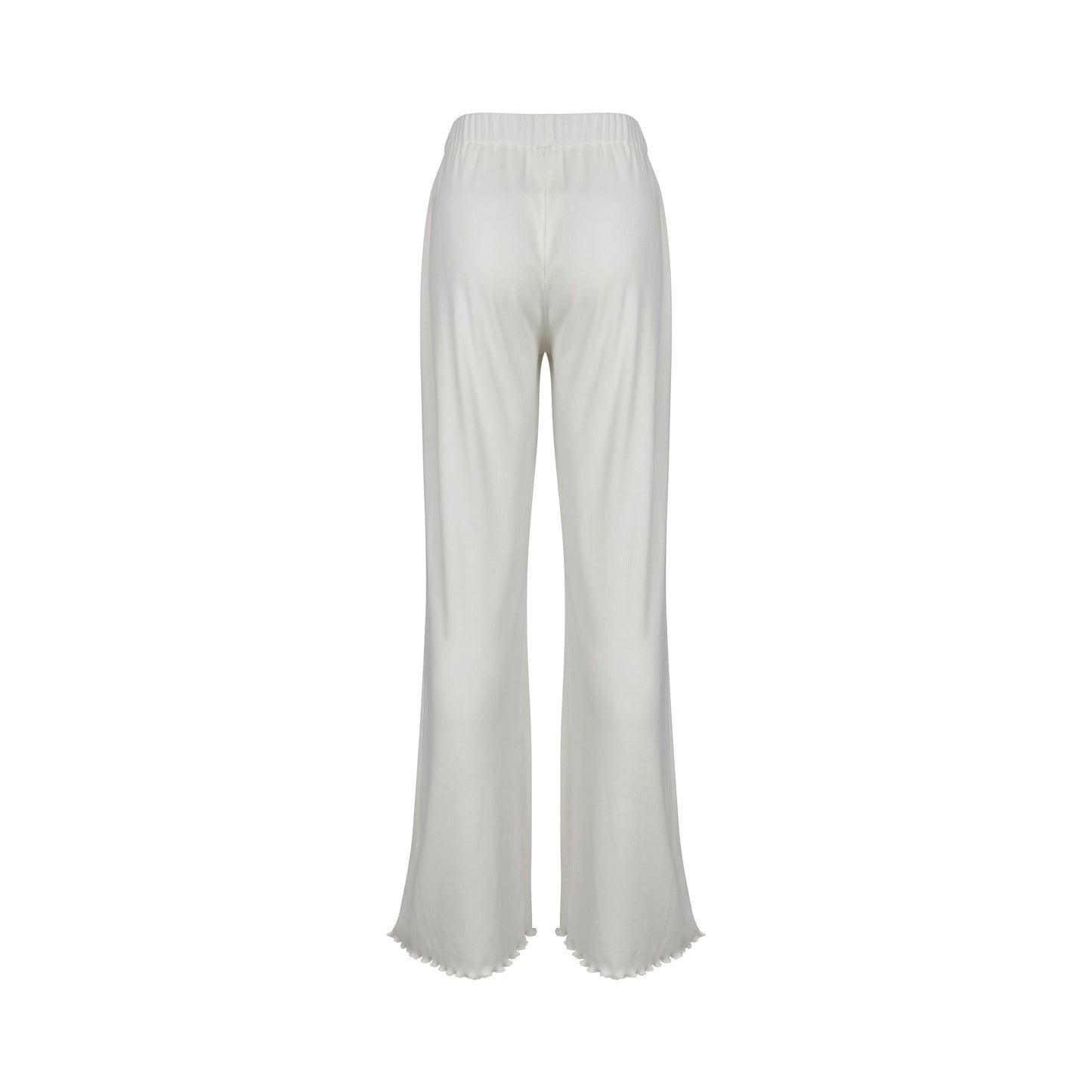 Woman in white ribbed flare pants and top, standing by doorway