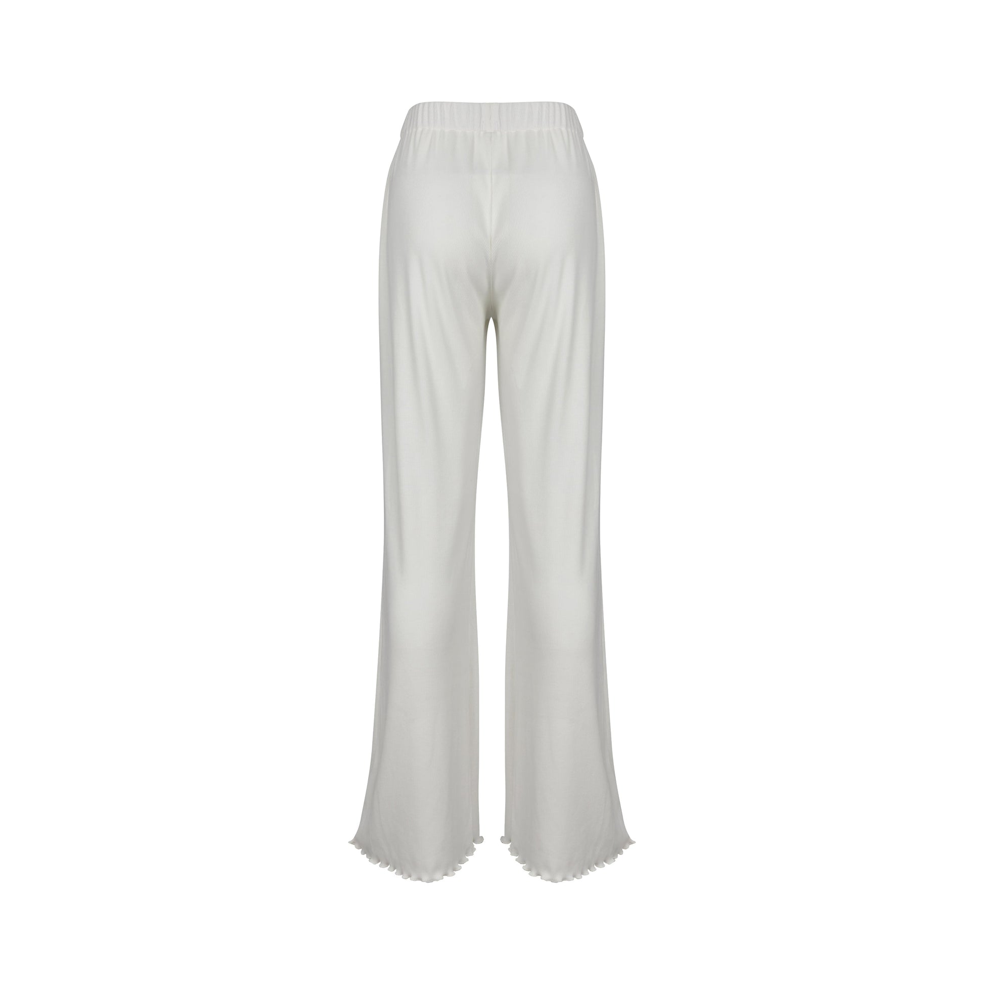 Woman in white ribbed flare pants and top, standing by doorway